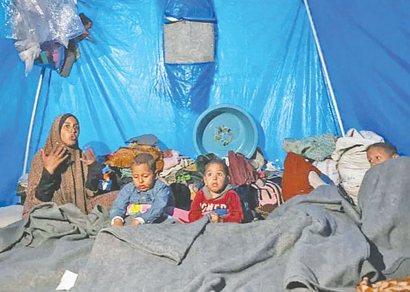 তীব্র শীতে তাঁবুতে শিশুসন্তানদের নিয়ে এক ফিলিস্তিনি মা। গত রোববার গাজার খান ইউনিসে