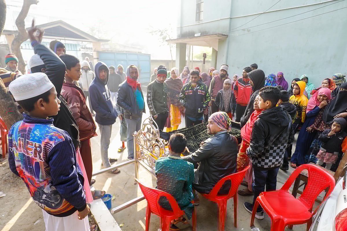 গুলিতে নিহত গোলাম রব্বানীর লাশে পাশে নির্বাক বসে আছেন স্বজনেরা। আজ শনিবার সকালে খুলনা নগরের দৌলতপুর এলাকায়
