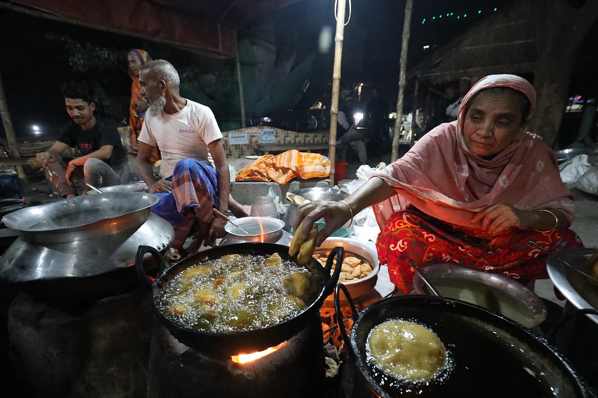 বগুড়া শহরের শহীদ চান্দু স্টেডিয়ামের ফটকে বেগুনি বেগমের পিঠার দোকান। গতকাল মঙ্গলবার সন্ধ্যায়