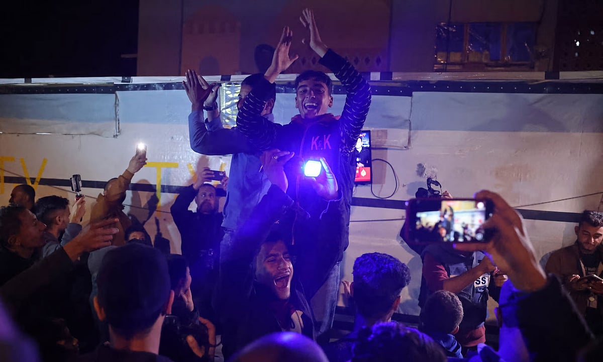 যুদ্ধবিরতির খবর টেলিভিশনে দেখে উল্লাস করছেন ফিলিস্তিনিরা। দক্ষিণ গাজায়, ১৫ জানুয়ারি ২০২৫