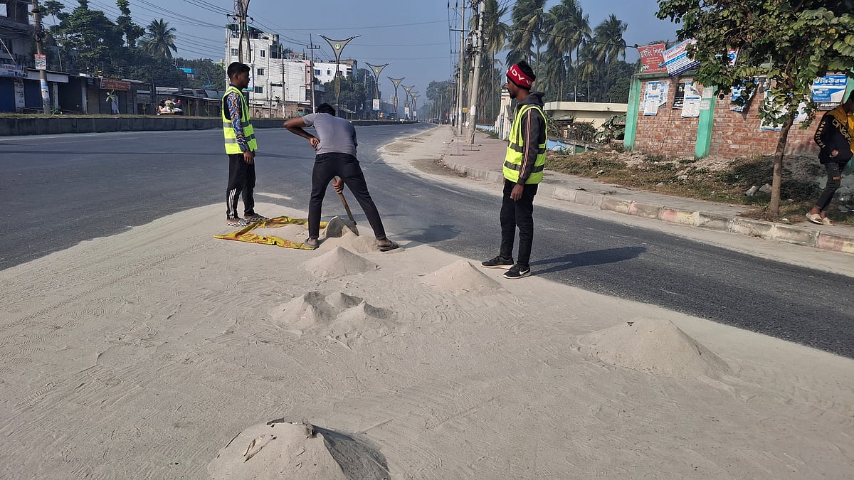 সড়কে থাকা বালু সরিয়ে নিচ্ছেন রাজশাহী সিটি করপোরেশনের কর্মীরা। আজ শুক্রবার সকাল ১০টার দিকে নগরের চৌদ্দপায়ের বিহাস এলাকায়