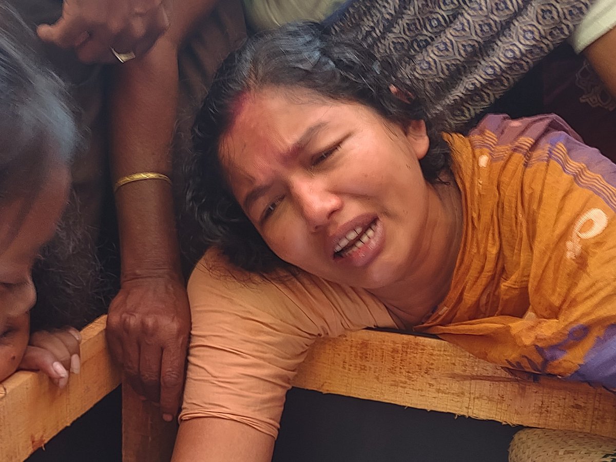 শেষকৃত্য অনুষ্ঠানে স্বামী রুবেল বড়ুয়ার লাশের পাশে বসে আহাজারি করছেন স্ত্রী শ্যামলী বড়ুয়া। আজ দুপুরে মিরসরাইয়ের মায়ানি বড়ুয়াপাড়ায়