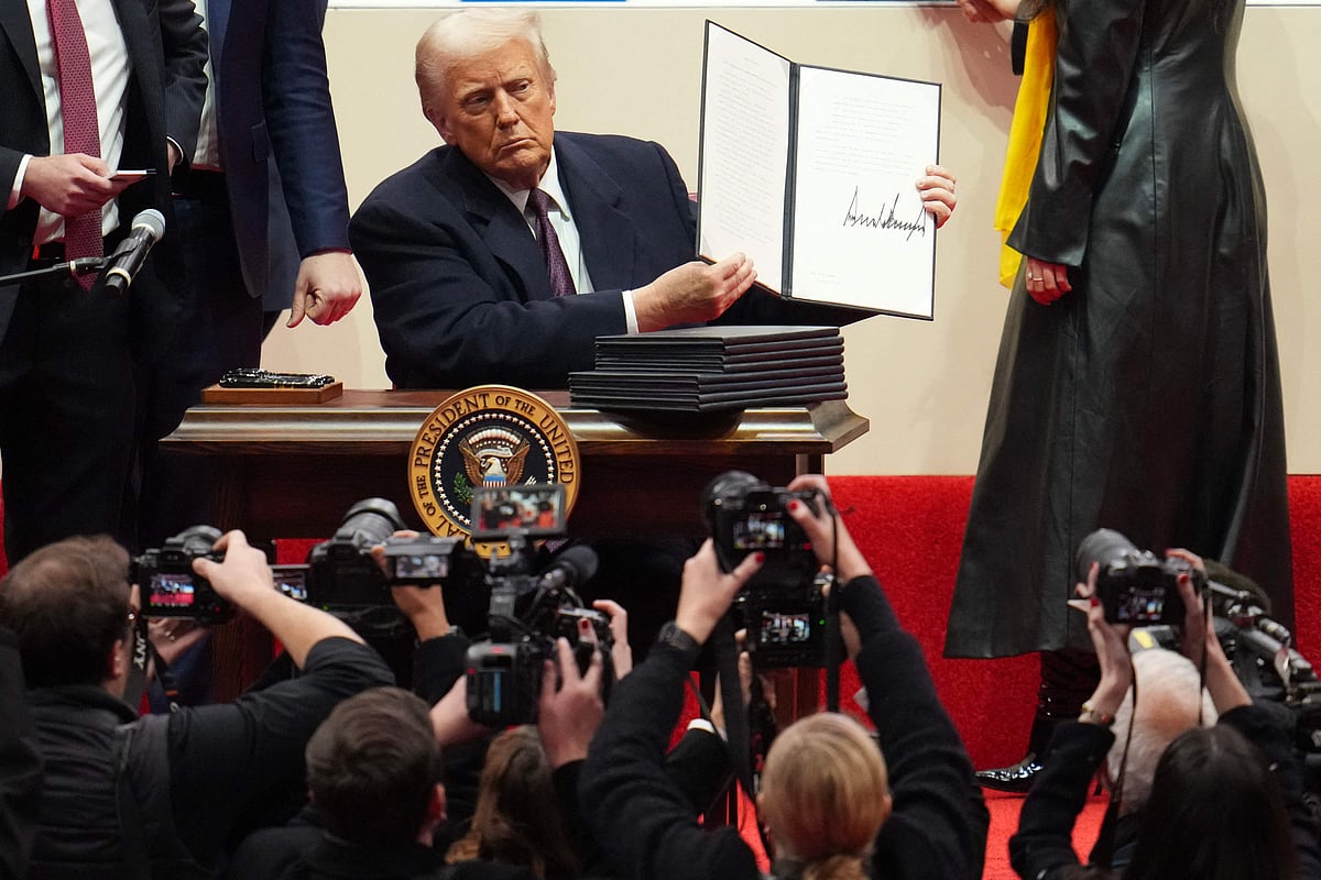 শপথ নেওয়ার পর নির্বাহী আদেশে সই করে সাংবাদিকদের দেখাচ্ছেন প্রেসিডেন্ট ডোনাল্ড ট্রাম্প। ২০ জানুয়ারি ২০২৫