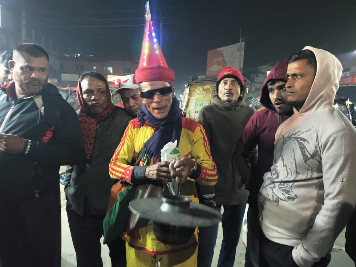 বিশেষ পোশাক ও মাথায় লম্বা টুপি পরে নিজ হাতে তৈরি ঘটিগরম চানাচুর বিক্রি করেন রংপুরের বাবু মিয়া