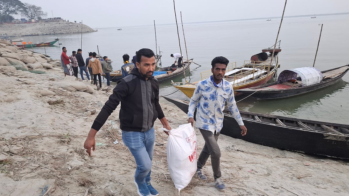 মৃত পাখিগুলা উদ্ধার করে নিয়ে যাচ্ছেন বন বিভাগের কর্মীরা। আজ মঙ্গলবার পদ্মার চরে