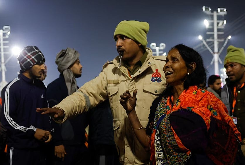 কুম্ভমেলায় পদদলিত হওয়ার ঘটনার পর এক পুণ্যার্থীকে উদ্ধার করে নিয়ে যাচ্ছেন এক পুলিশ সদস্য