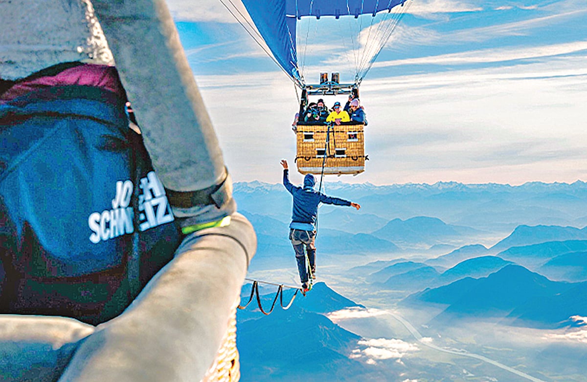 দুই বেলুনের মাঝখানে ঝুলতে থাকা দড়িতে হাঁটছেন লুকাস ইরমলার