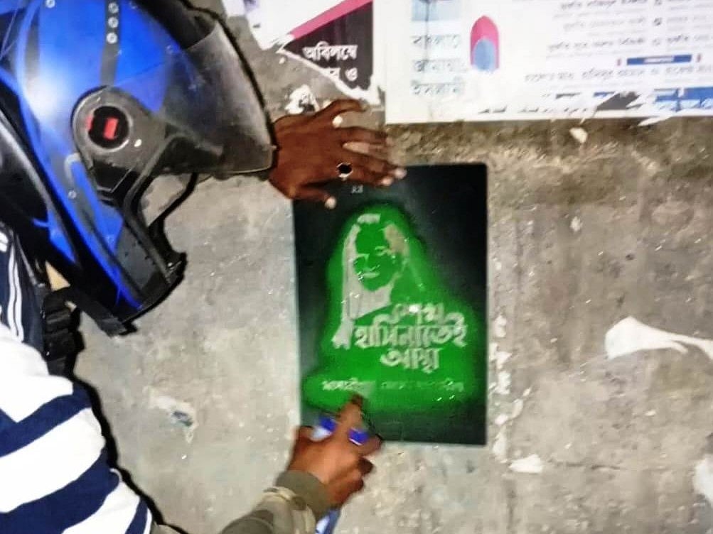 মাদারীপুর সদর উপজেলার তিনটি ইউনিয়নের বিভিন্ন দেয়ালে স্প্রে দিয়ে গ্রাফিতি আঁকেন হেলমেট পরা এক ব্যক্তি