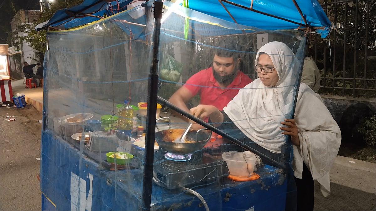 পিঠা-পিঁয়াজির ভ্রাম্যমাণ দোকানে মা হেলেনার সঙ্গে কাজ করছেন অর্ণব। গত বুধবার শহরের মুক্তিযোদ্ধা আলী হোসেন মনি সড়কে
