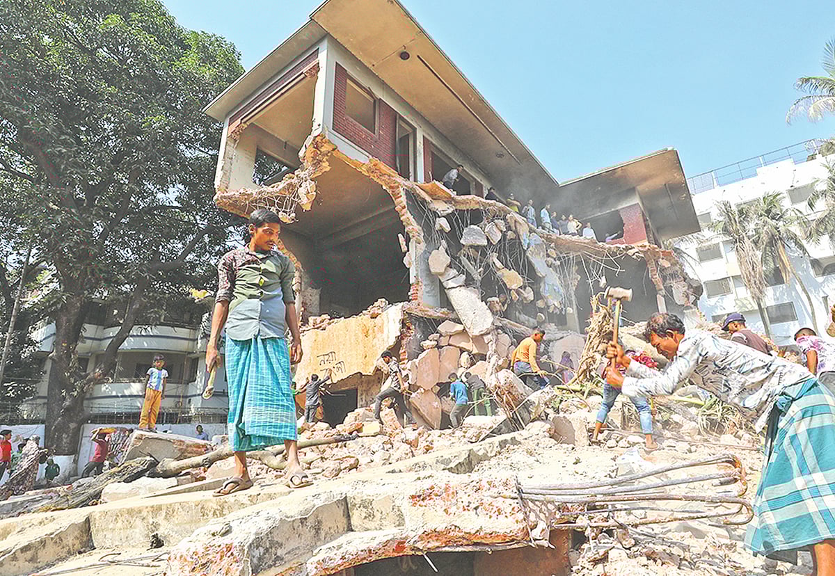 ধানমন্ডি ৩২ নম্বরের ভাঙা বাড়ি থেকে রড নেওয়ার চেষ্টায় লোকজন। গতকাল সকালে