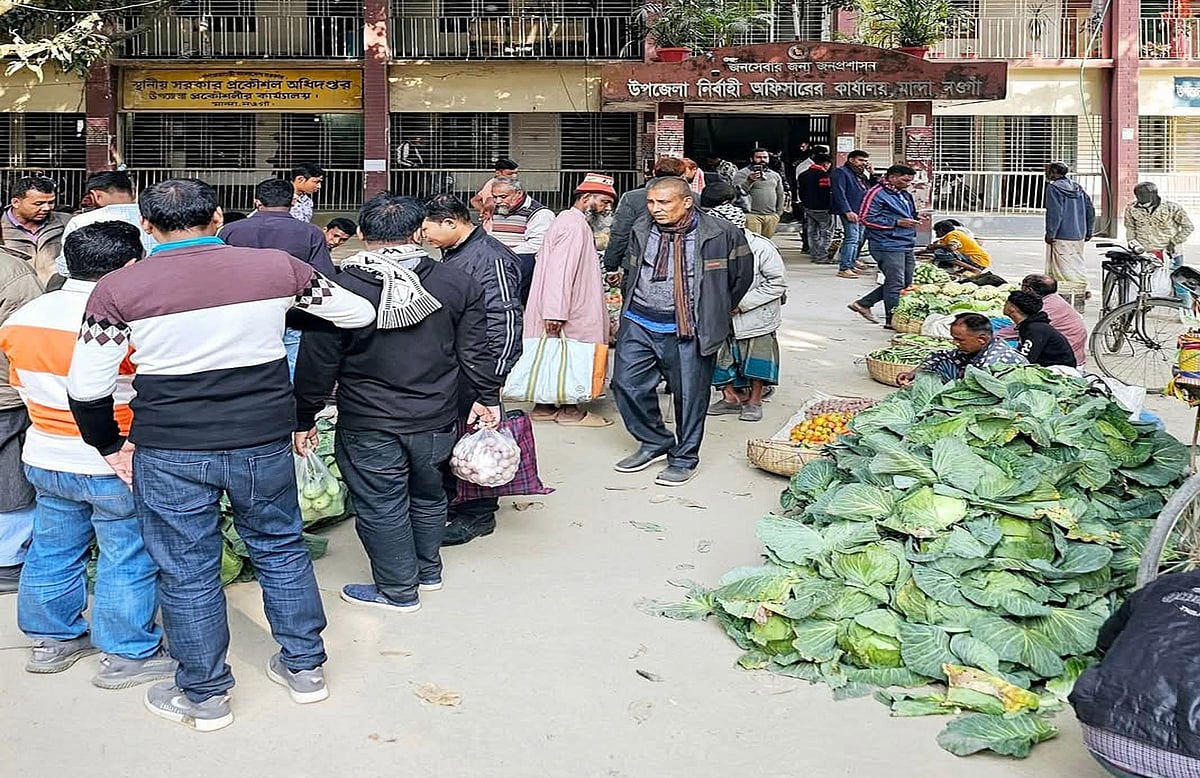 হাটের নির্ধারিত জায়গায় দোকান বসাতে না পেরে নওগাঁর মান্দায় ইউএনও অফিসের সামনে সবজির দোকান বসিয়ে কৃষকদের প্রতিবাদ। রোববার বিকেলে