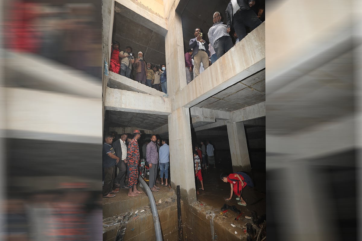 ৩২ নম্বরের বাড়ি সংলগ্ন পূর্ব পাশের নির্মাণাধীন একটি ভবনে আন্ডারগ্রাউন্ডে জমে থাকা পানি সরাচ্ছে ফায়ার সার্ভিস। সেখানে উৎসুক মানুষের ভিড়। আজ রোববার দুপুরে