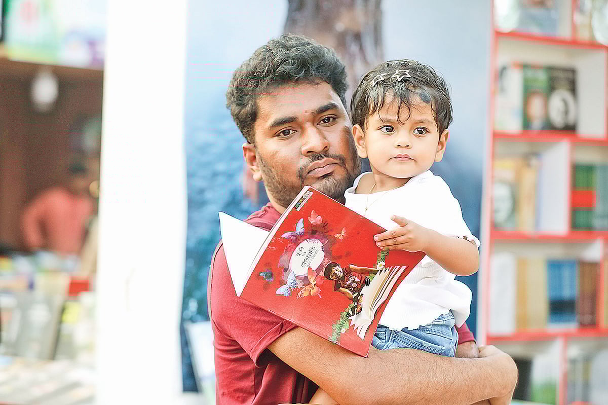 ছোট্ট শিশুকে কোলে নিয়ে অমর একুশে বইমেলায় এসেছেন এই ব্যক্তি। শিশুটি তার পছন্দের বই নেড়েচেড়ে দেখছে। গতকাল বিকেলে সোহরাওয়ার্দী উদ্যানে