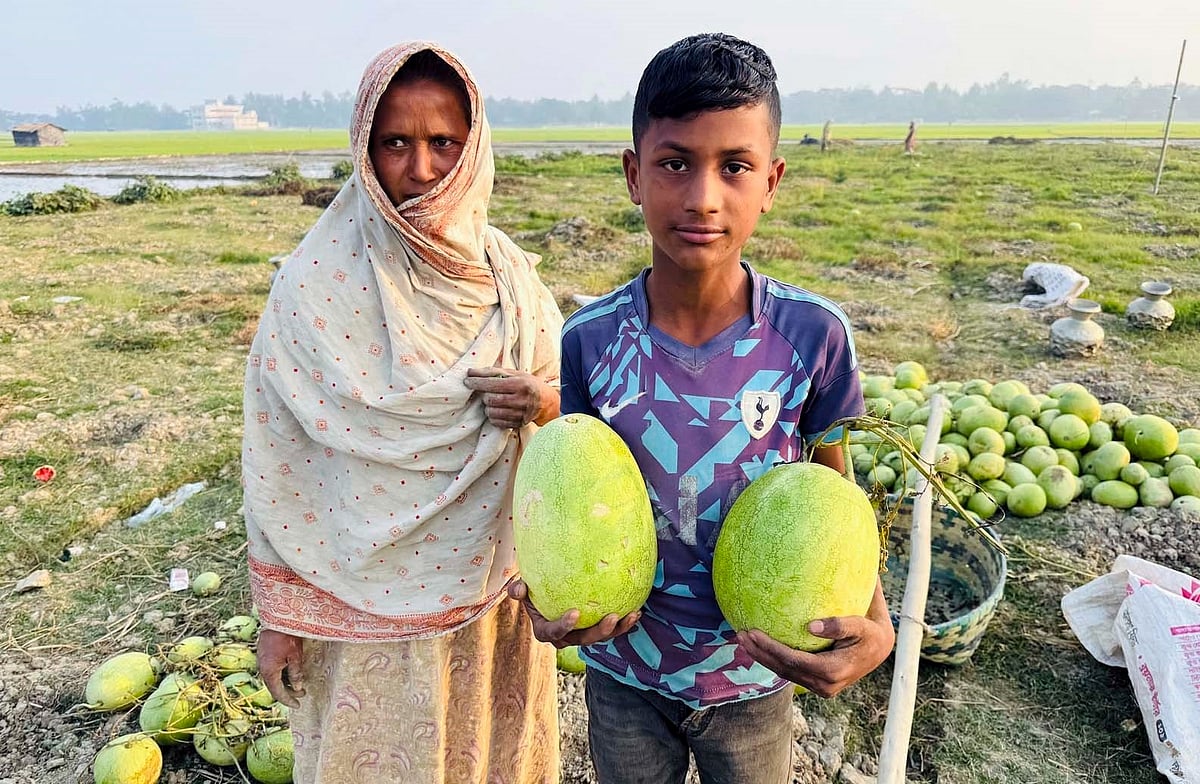 কক্সবাজারের কুতুবদিয়ার আলী আকবরডেইল ইউনিয়নের তরমুজখেতে গৃহবধূ কুলসুমা। পাশে তরমুজ হাতে তাঁর ছেলে। সম্প্রতি তোলা