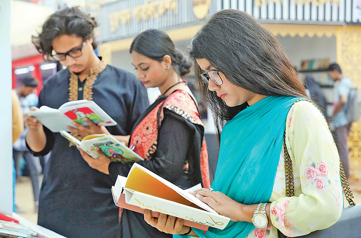 বই দেখছেন কয়েকজন পাঠক। গতকাল বিকেলে সোহরাওয়ার্দী উদ্যানে