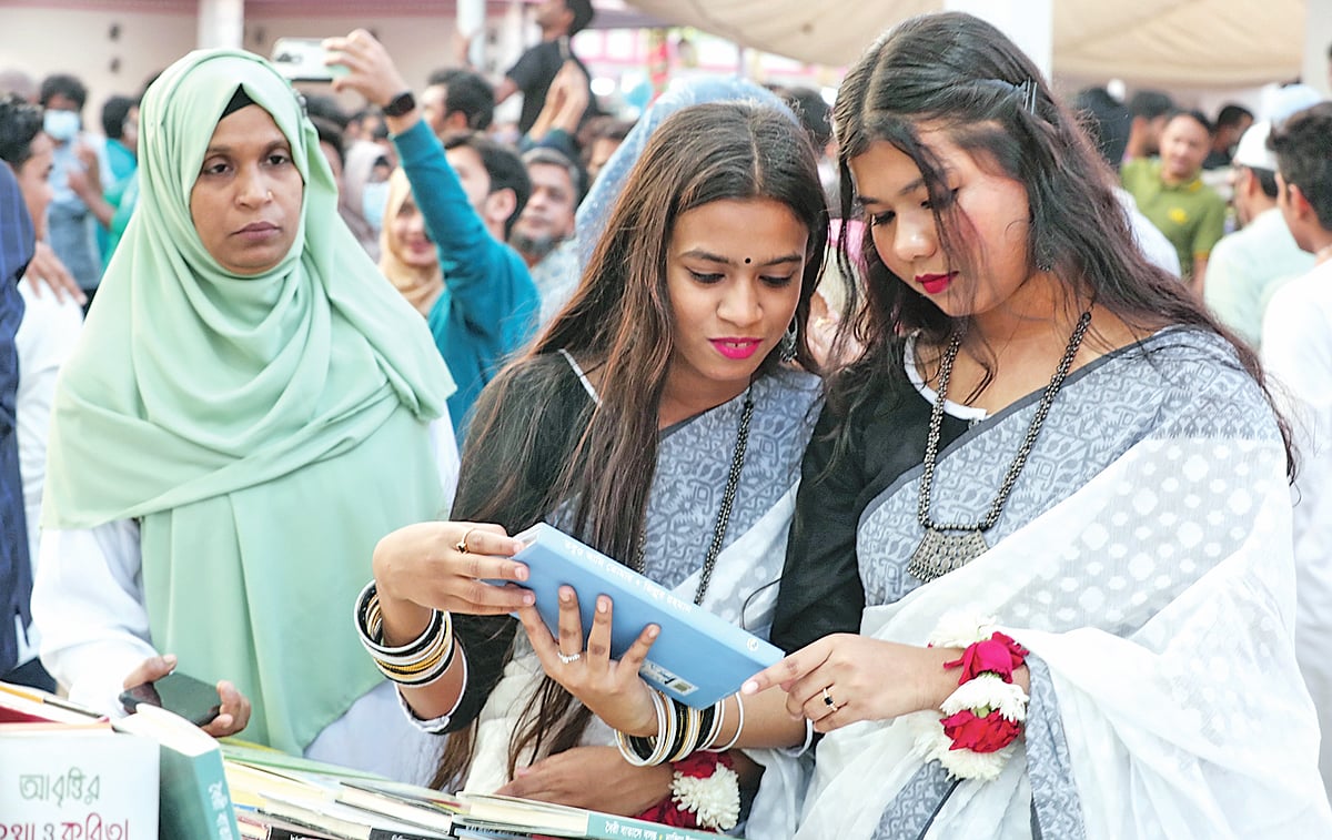 একুশে ফেব্রুয়ারির বইমেলায় কয়েকজন বইপ্রেমী। গতকাল সোহরাওয়ার্দী উদ্যানে
