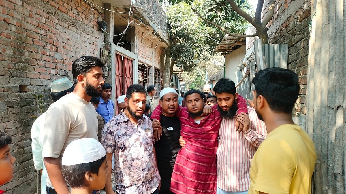 মা, স্ত্রী ও সন্তানকে হারিয়ে চলাচলের শক্তিও যেন হারিয়েছেন ব্যাংক কর্মকর্তা নোমানুর রশিদ(মাঝে লাল পাঞ্জাবি পরা)। আজ দুপুরে কর্ণফুলী উপজেলার বড় উঠানে