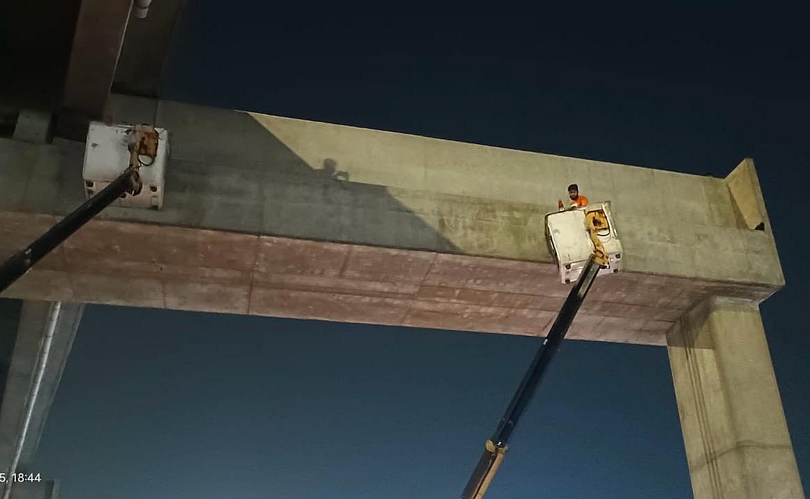 দুটি লেডারের সাহায্যে বিড়ালটিকে উদ্ধারের চেষ্টা করেন উত্তর সিটি করপোরেশনের কর্মীরা