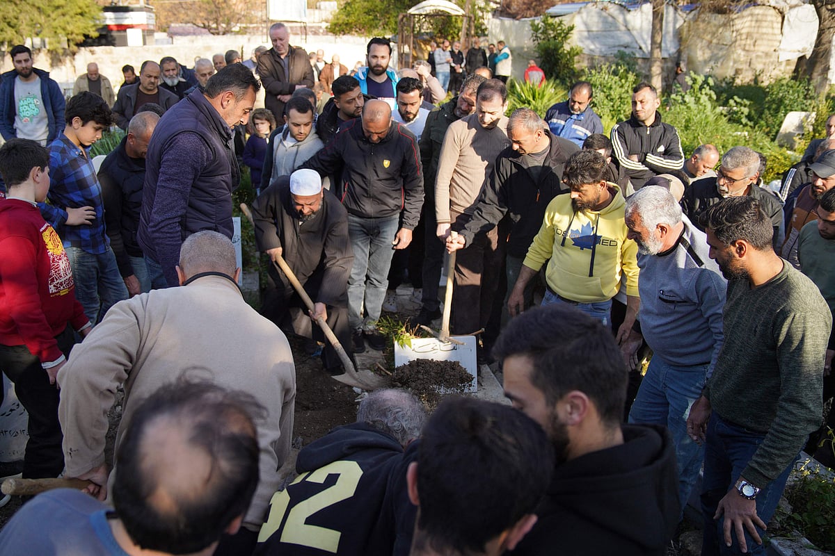 নিহত এক ব্যক্তিকে কবর দিচ্ছেন স্বজনেরা। সিরিয়ার উপকূলীয় লাতাকিয়া প্রদেশের জাবলেহ শহরে, ১০ মার্চ ২০২৫