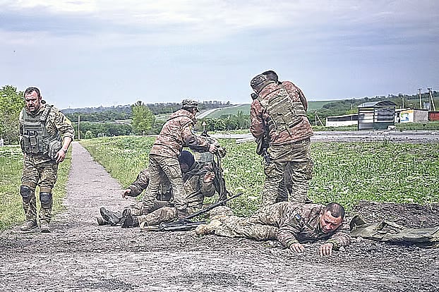 যুদ্ধক্ষেত্র থেকে আহত এক সহযোদ্ধাকে নিয়ে যাচ্ছেন ইউক্রেনের সেনারা। এ যুদ্ধ বন্ধ হওয়া নিয়ে তাঁরা খুব বেশি আশাবাদী হতে পারছেন না