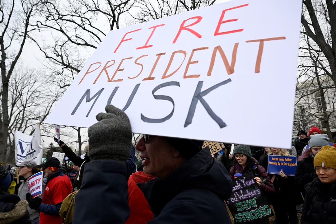 ফেডারেল কর্মীদের চাকরিচ্যুত করার প্রতিবাদে এক বিক্ষোভে অংশ নেন অনেকে। এ সময় প্রেসিডেন্ট ট্রাম্প ও তাঁর ঘনিষ্ঠ সহযোগী ধনকুবের মাস্ককে ‘বরখাস্তের’ দাবিসংবলিত প্ল্যাকার্ড বহন করতে দেখা যায় একজনকে। ক্যাপিটল হিল, ওয়াশিংটন, যুক্তরাষ্ট্র, ১১ ফেব্রুয়ারি ২০২৫