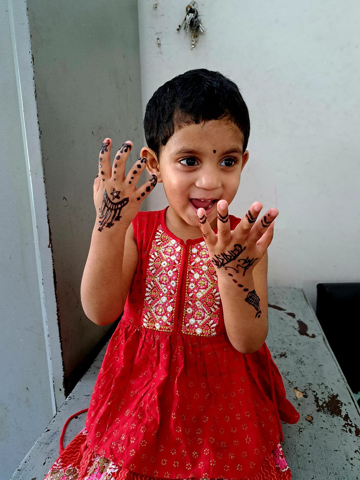 নতুন জামা পরে হাতে মেহেদি দিয়ে বেজায় খুশি ফাতেমা। ঢাকা, ৩০ মার্চ