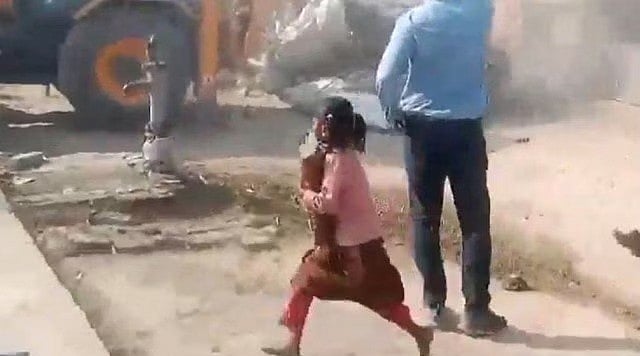 ভারতের উত্তর প্রদেশের আম্বেদকরনগরে উচ্ছেদ অভিযান চলাকালে বইভর্তি স্কুলব্যাগটি উদ্ধার করে দৌড়ে পালাচ্ছে আট বছরের অনন্যা যাদব