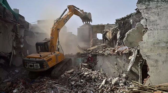 ভারতের উত্তর প্রদেশের এলাহাবাদে বুলডোজার দিয়ে ভেঙে ফেলা হচ্ছে জাভেদ মোহাম্মদ নামের এক ব্যক্তির বাড়ি। ২০২২ সালে তোলা