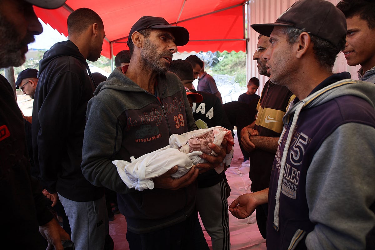 গাজার জাবালিয়া শরণার্থীশিবিরে ইসরায়েলি হামলায় নিহত শিশুর মরদেহ হাতে এক ফিলিস্তিনি। ২ এপ্রিল, উত্তর গাজা