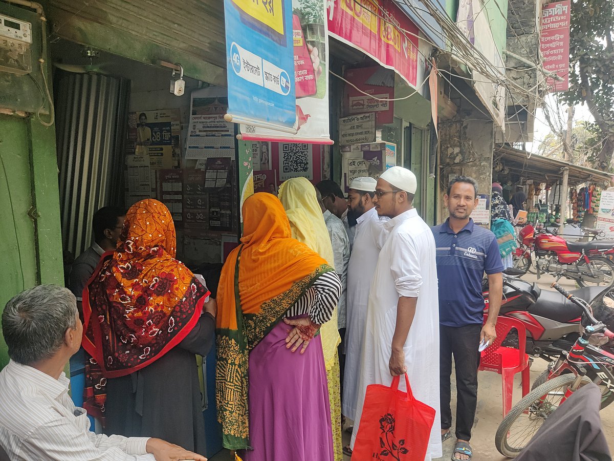 ইসলামী ব্যাংকের এজেন্ট শাখার নিচের একটি দোকানে বসে প্রতারিত গ্রাহকের সঙ্গে কথা বলছেন বাংলাদেশ ব্যাংকের কর্মকর্তারা। আজ রোববার দুপুরে জয়পুরহাটের আক্কেলপুরে