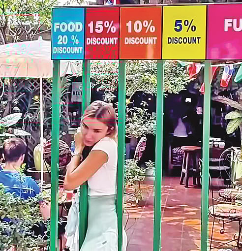 ১৫ শতাংশের মূল্যছাড়ের ফটক দিয়ে প্রবেশের পর বের হচ্ছেন এক নারী। থাইল্যান্ডের চিয়াং মাই ব্রেকফাস্ট ওয়ার্ল্ড রেস্তোরাঁয়