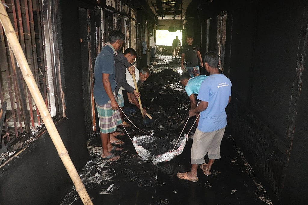 অগ্নিকাণ্ডে পুড়ে যাওয়া জিনিসপত্র অপসারণ করছেন শ্রমিকেরা। আজ বৃহস্পতিবার সকালে দিনাজপুর এলজিইডি ভবনের দ্বিতীয় তলায়