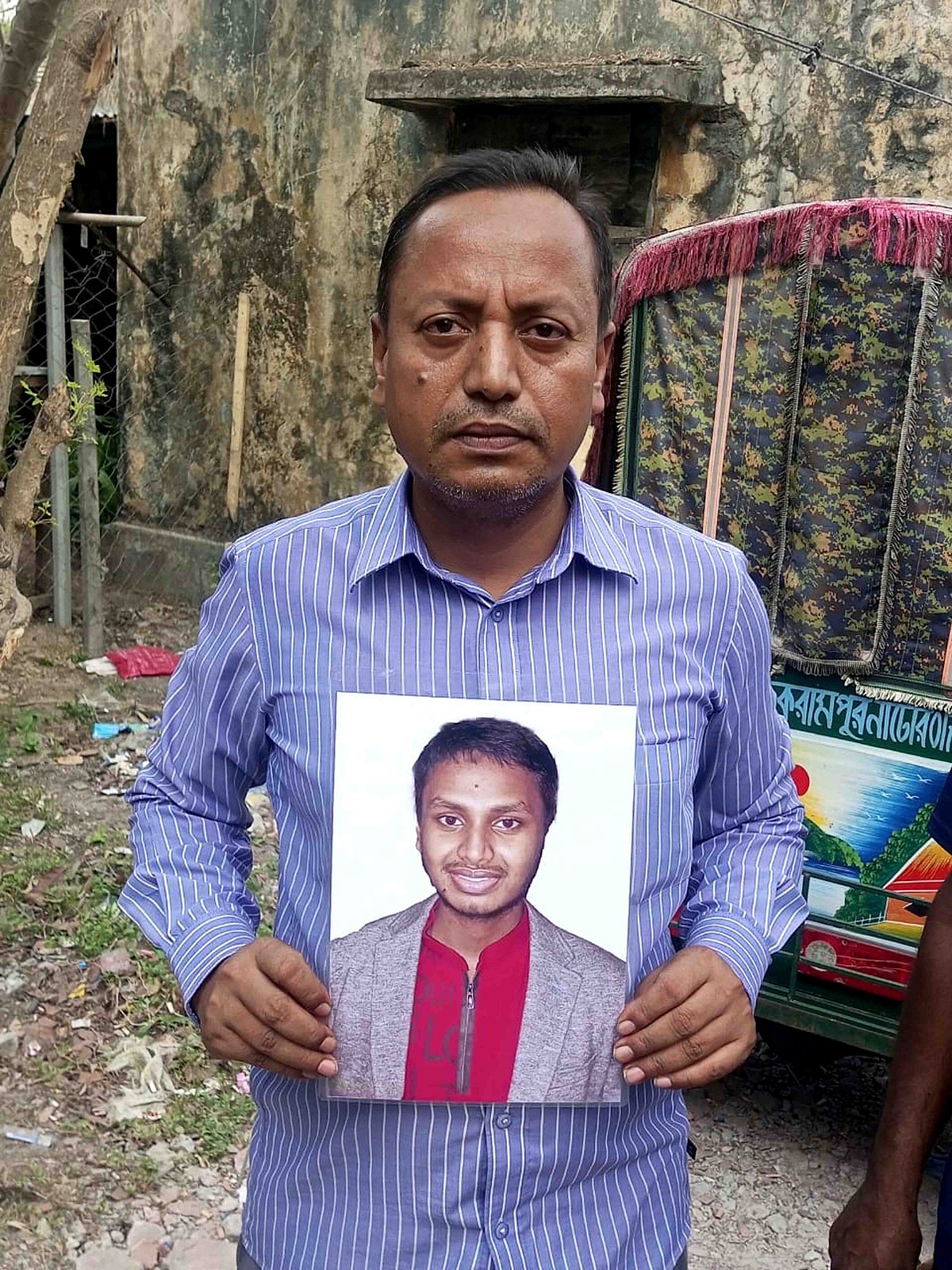 নিখোঁজ ছেলের ছবি হাতে বাবা এজাজুল হক। আজ বৃহস্পতিবার সকালে নাটোর সরকারি বালিকা উচ্চবিদ্যালয় কেন্দ্রের সামনে