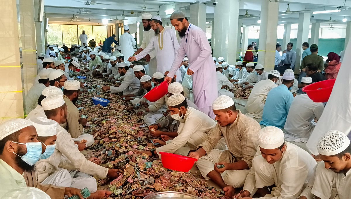 কিশোরগঞ্জের পাগলা মসজিদের দানসিন্দুকে পাওয়া টাকা গণনার কাজ করছেন মাদ্রাসার শিক্ষার্থীসহ অন্যরা