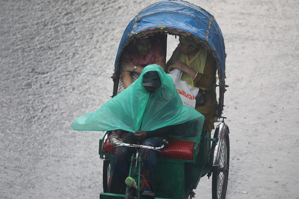 বৃষ্টির মধ্যে রিকশায় চড়ে চলেছেন দুই যাত্রী। ধানমন্ডি ২৭ নম্বর থেকে তোলা