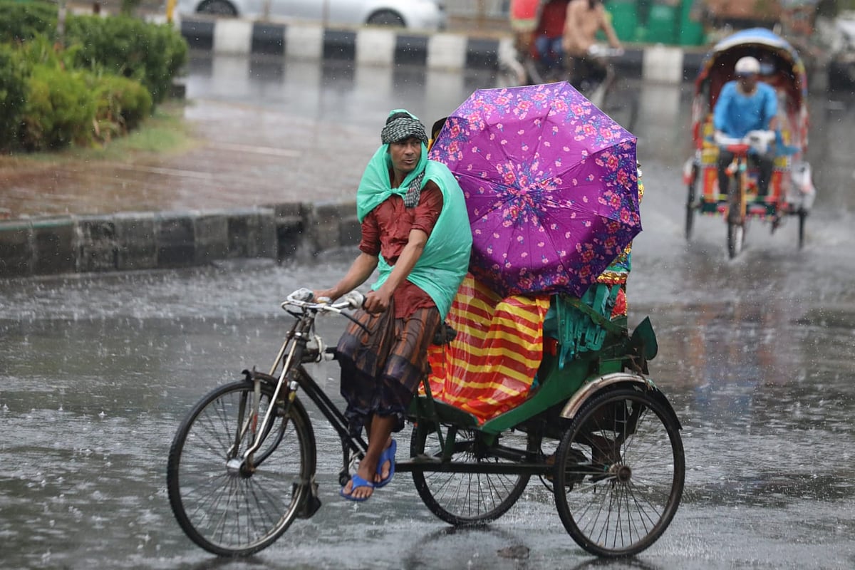 বৃষ্টিতে রাজধানীর সড়কে যাত্রী নিয়ে চলছে রিকশা। খামারবাড়ি, ঢাকা, ১৭ এপ্রিল