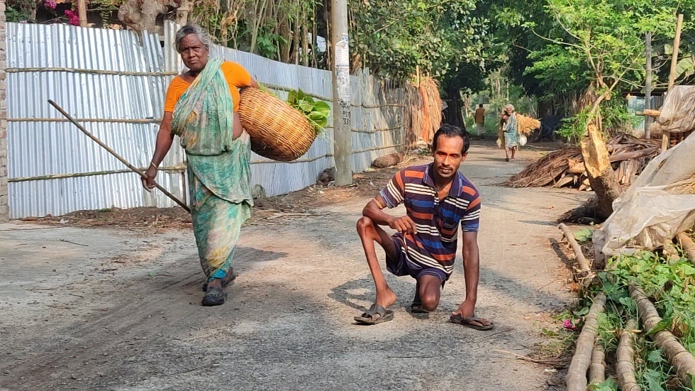 মা কাজল রানির সঙ্গে হামাগুড়ি দিয়ে বাড়ি ফিরছেন মধু মহালদার (৩৫)। শুক্রবার সকালে নড়াইল সদর উপজেলার শোলপুর গ্রামে
