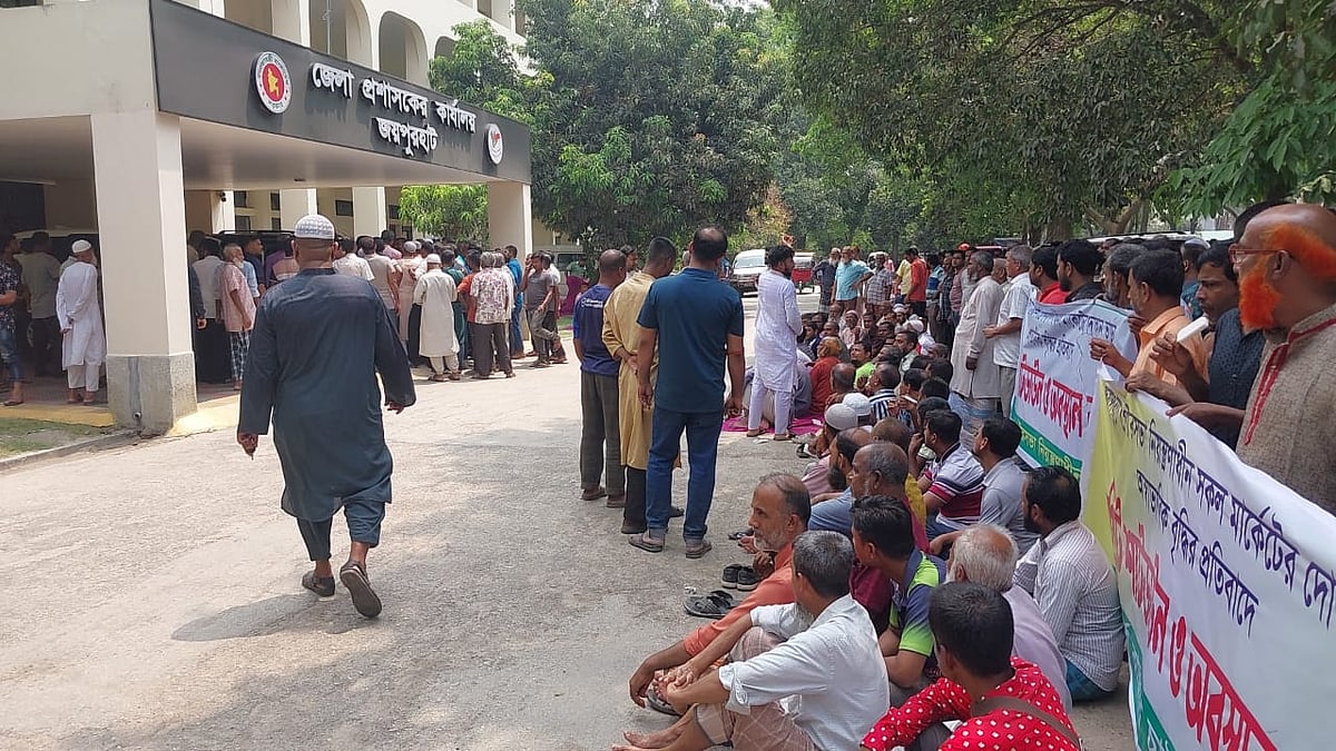 জয়পুরহাট পৌরসভার নিয়ন্ত্রণাধীন মার্কেটগুলোর দোকানের ভাড়া বাড়ানোর প্রতিবাদে ব্যবসায়ীদের অবস্থান কর্মসূচি। আজ রোববার দুপুরে জেলা প্রশাসকের কার্যালয়ের সামনে