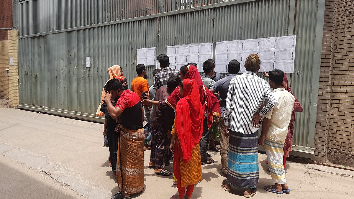 গাজীপুর মহানগরীর কোনাবাড়ী এলাকায় তুসুকা গ্রুপের শ্রমিকদের ছাঁটাইয়ের তালিকা দেখছেন শ্রমিকেরা। আজ বুধবার দুপুরে