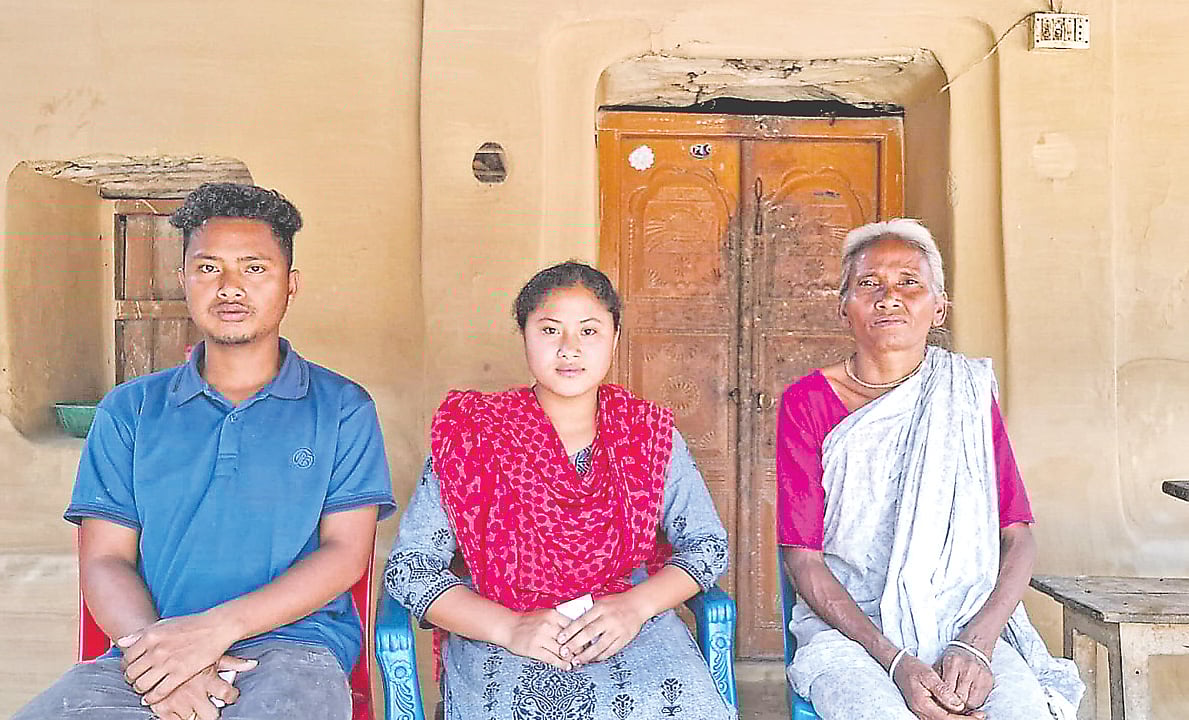 শহীদ কমরেড কম্পরাম সিংহের ঘরের বারান্দায় বড় নাতির বউ বসুমতী রায় (ডানে), ছোট নাতির ছেলে অর্জুন সিংহ ও মেয়ে জ্যোতি রানী সিংহ। গত ১৫ মার্চ ঠাকুরগাঁওয়ের বালিয়াডাঙ্গী উপজেলার উত্তর পাড়িয়া শালডাঙ্গা গ্রামে