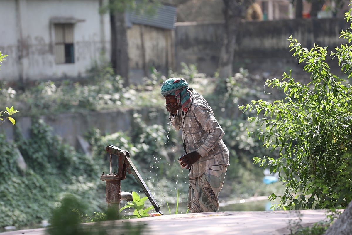 বৈশাখের তপ্ত দুপুরে কাজের ফাঁকে টিউবওয়েলের পানি পান করছেন এক মজুর। পতিসর এলাকা, আত্রাই উপজেলা, নওগাঁ, ২৫ এপ্রিল