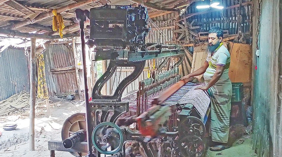বগুড়া জেলার আদমদীঘি উপজেলায় তাঁতে পণ্য তৈরি করছেন এক কারিগর