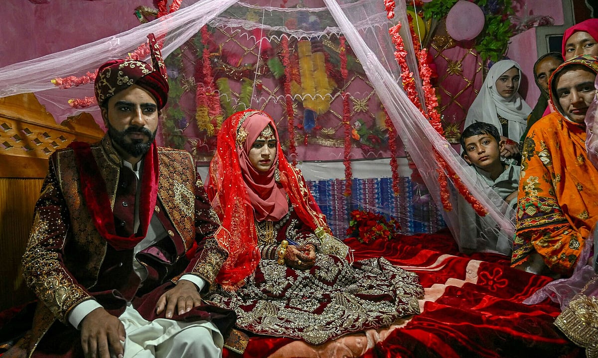 ফুলের মালা দিয়ে সাজানো পালকিতে কনে রাবেয়া বিবি (ডানে) ও বর চৌধুরী জুনায়েদ। পাকিস্তান–নিয়ন্ত্রিত কাশ্মীরের নীলুম ভ্যালির আশকোট গ্রামে, ৩ মে ২০২৫। ছবি: এএফপি