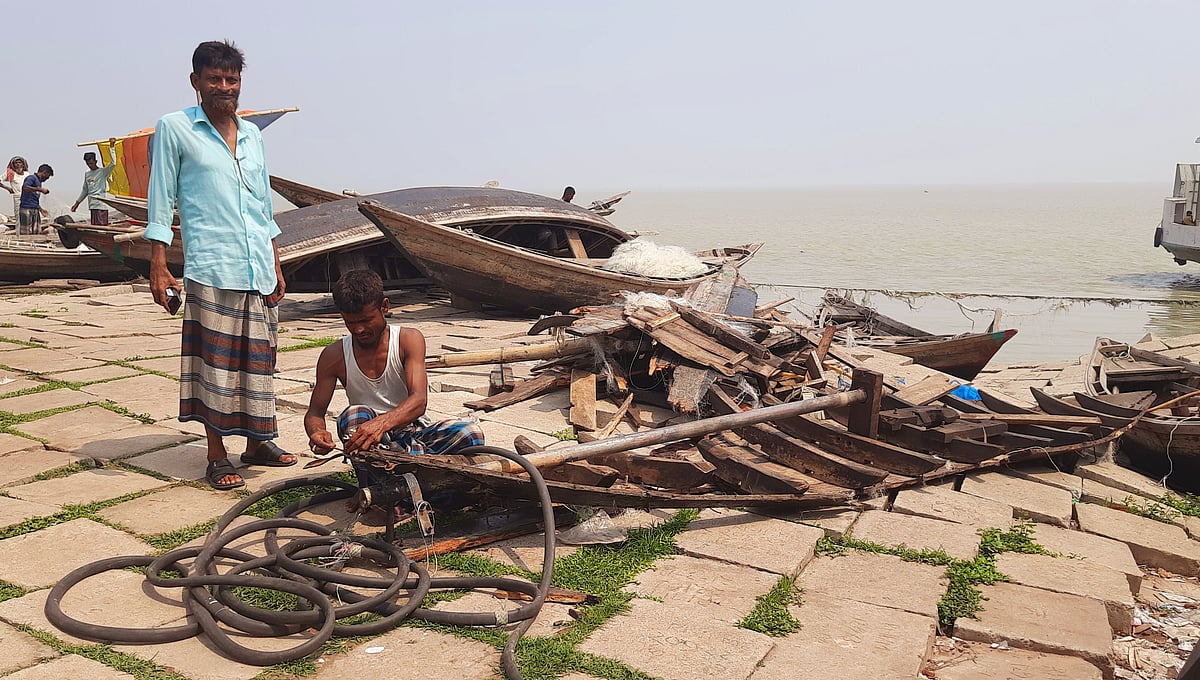 ঝড়ে বিধ্বস্ত নৌকা মেরামতের চেষ্টা করছেন এক জেলে। আজ শুক্রবার সকালে ভোলা সদর উপজেলার উত্তর ইলিশার চড়ার মাথা মাছঘাট এলাকায়