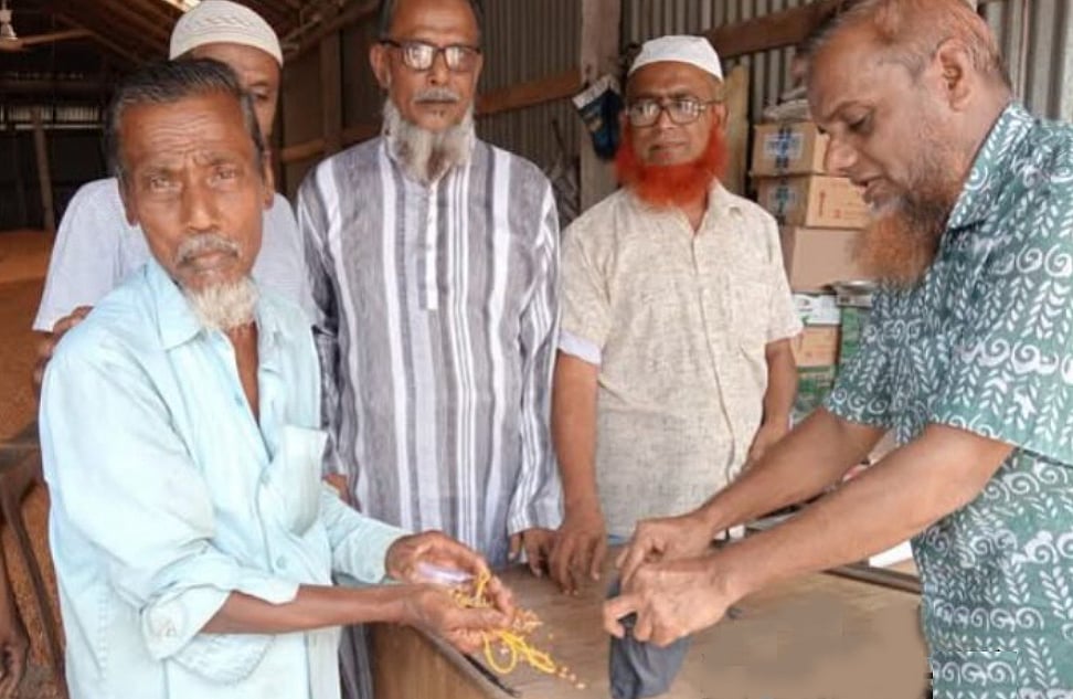 ভুট্টার বস্তায় পাওয়া স্বর্ণালংকার প্রকৃত মালিককে ফিরিয়ে দিচ্ছেন ভুট্টা ব্যবসায়ী। শুক্রবার দুপুরে চাঁদপুরের মতলব দক্ষিণ উপজেলার কফি হাউস এলাকায়