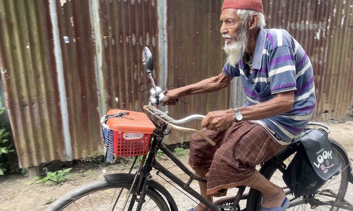 সাইকেল চালাচ্ছেন আনোয়ার হোসেন। সম্প্রতি নাটোরের সিংড়ার ধুলাউড়িতে