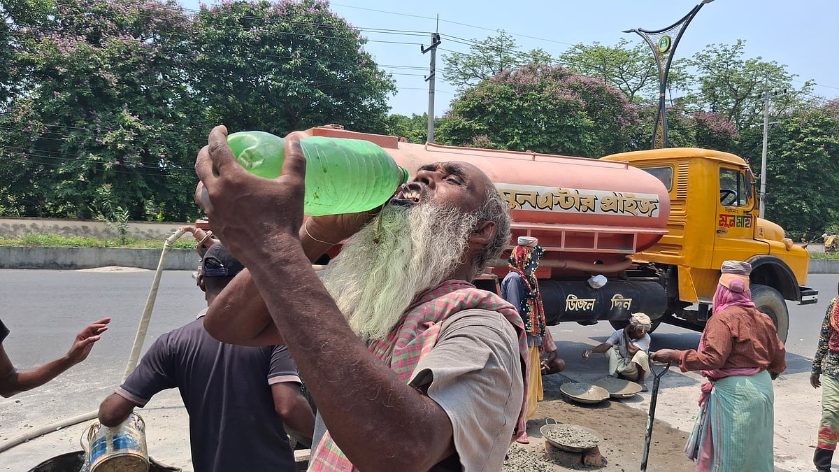 কাজের ফাঁকে পানি পান করছেন এক শ্রমিক। আজ রোববার দুপুরে রাজশাহী নগরের চৌদ্দপাই এলাকায়