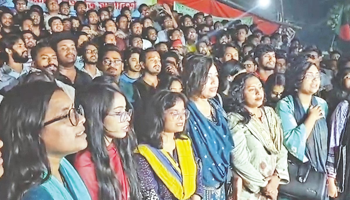 সম্মিলিত কণ্ঠে জাতীয় সংগীত গাইছেন শিক্ষার্থীরা। জাতীয় সংগীত গাইতে বাধা দেওয়ার প্রতিবাদে এই কর্মসূচি ডাকা হয়। গতকাল সন্ধ্যা সাতটায় ঢাকা বিশ্ববিদ্যালয়ের রাজু ভাস্কর্যের পাদদেশে