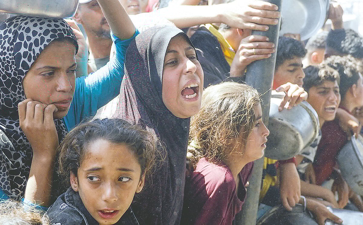 রান্না করা খাবার দেবে একটি দাতব্য সংস্থা। খাবার নিতে শিশু–কিশোরদের হুড়োহুড়ি। সম্প্রতি দক্ষিণ গাজার খান ইউনিসে