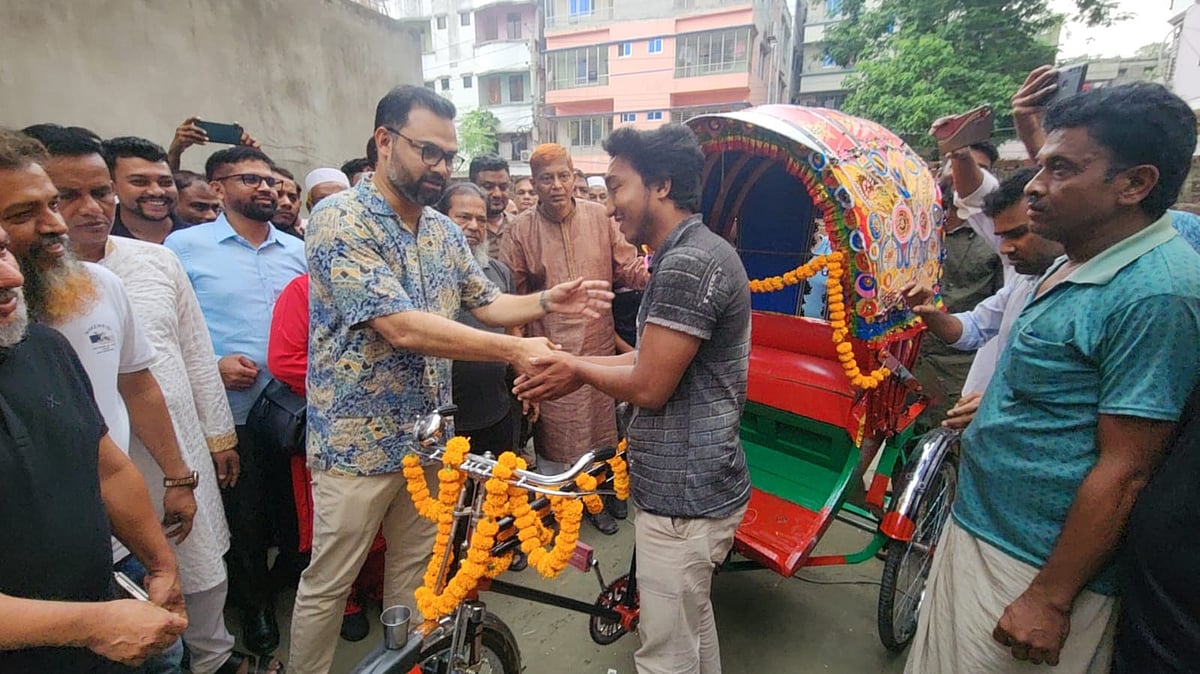 ঢাকা উত্তর সিটি করপোরেশনের অভিযানে ক্ষতিগ্রস্ত ব্যাটারিচালিত রিকশার চালককে প্যাডেলচালিত রিকশা উপহার দিচ্ছেন ঢাকা মহানগর উত্তর বিএনপির আহ্বায়ক আমিনুল হক